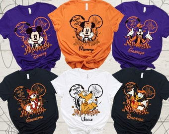 May include: Six t-shirts with different Disney characters for Halloween. The shirts are orange, purple, black, and white. Each shirt has a different character, including Mickey Mouse, Minnie Mouse, Goofy, Donald Duck, and Pluto. The shirts all have the text "Trick or Treat" and "Halloween" on them.