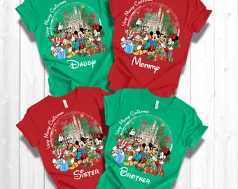 May include: Four green and red t-shirts with a Christmas theme featuring Mickey Mouse and friends in front of Cinderella's Castle. The shirts have the text "Very Merry Christmas" and the words "Daddy", "Mommy", "Sister", and "Brother" printed on them.