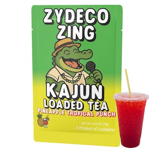 May include: A green and yellow packet of "Zydeco Zing Kajun Loaded Tea Pineapple Tropical Punch" with a cartoon alligator wearing a hat and holding a microphone. A clear plastic cup with a red drink and a straw is next to the packet.