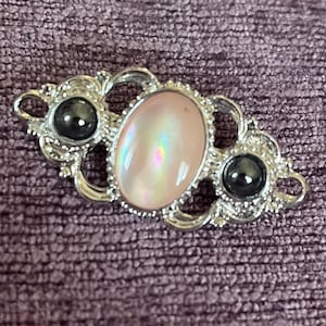 Beautiful vintage brooch with black stones and a beautiful rose gold toned stone in the middle