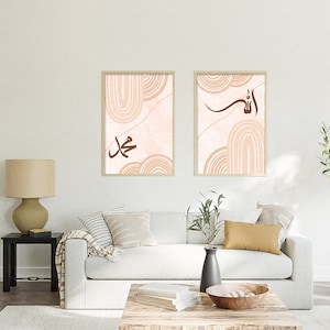 Puede incluir: Dos impresiones enmarcadas con diseños abstractos en tonos rosa y marrón. Las impresiones presentan caligrafía árabe, con las palabras "Allah" y "Muhammad" en marrón.