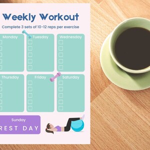 May include: A weekly workout planner with the title "Weekly Workout" and exercise instructions. The planner includes boxes for each day of the week, with a rest day on Sunday. A cup of coffee sits on a saucer next to the planner.