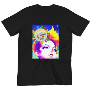 Puede incluir: Una camiseta negra con un gráfico colorido de una persona con el pelo arcoíris. El gráfico incluye el texto "Neuro-D and Proud to Be Me".