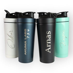 May include: Four insulated water bottles in white, navy blue, black, and teal. Each bottle has a black lid and a silver inscription. The navy blue bottle has the text "AKUMA LABS" and Japanese characters. The other bottles have names.