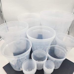 May include: A set of clear plastic plant pots of various sizes. The pots are stacked and arranged on a black surface.