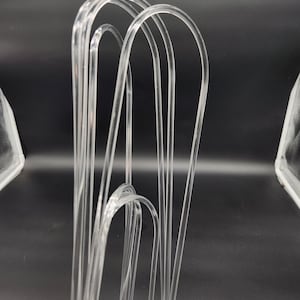 May include: A set of clear plastic hangers, designed for hanging clothes. The hangers are made of a flexible, durable material and are designed to prevent clothes from slipping off.