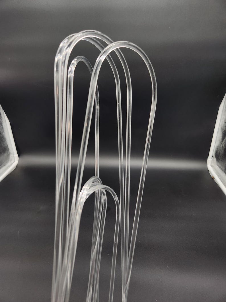 May include: A set of clear plastic hangers, designed for hanging clothes. The hangers are made of a flexible, durable material and are designed to prevent clothes from slipping off.