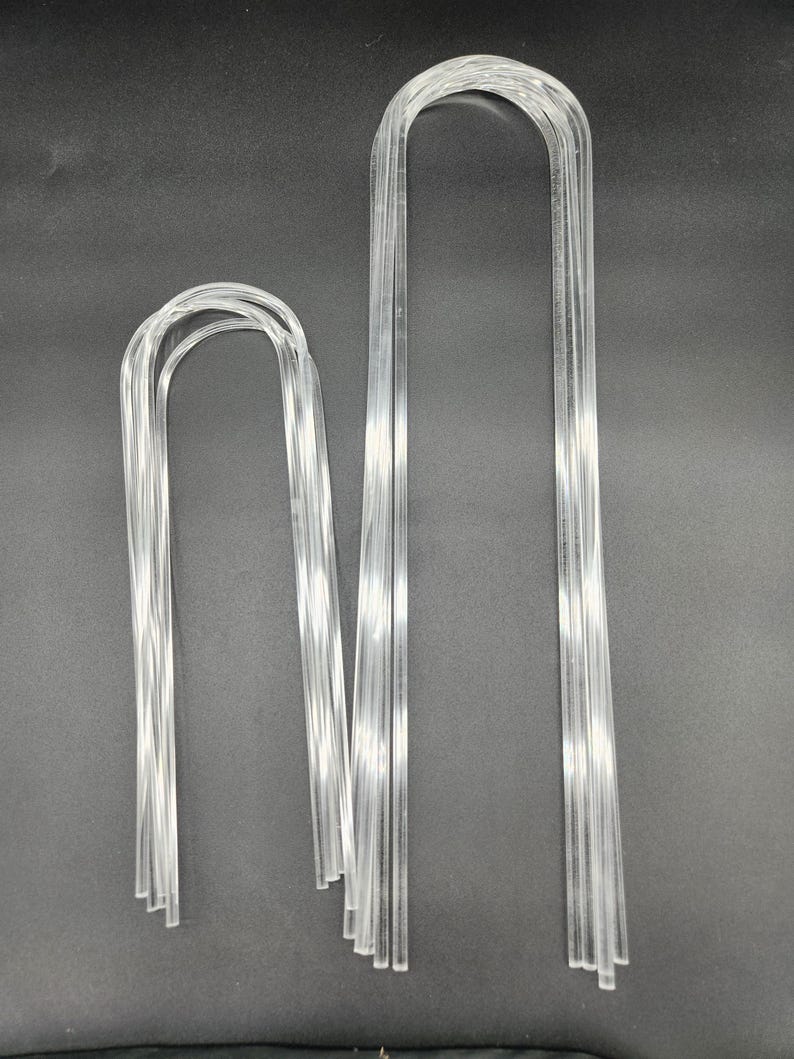 May include: Two sets of clear plastic U-shaped wire hangers. The larger set has 10 hangers and the smaller set has 5 hangers.