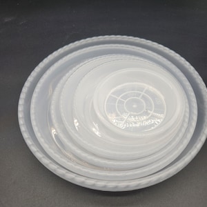 May include: Set of five clear plastic plant pots with a textured rim. The pots are stacked in decreasing size.