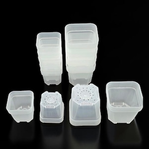 May include: A collection of translucent, square-shaped plastic plant pots in two distinct sizes. The pots feature drainage holes at the base and are arranged in two vertical stacks alongside two individual pots, showcasing their open tops and bases.