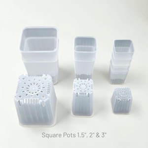 May include: A collection of clear, square plastic plant pots in three sizes, labeled as 1.5 inches, 2 inches, and 3 inches. The pots are arranged in stacks and individually, showing their open tops and drainage holes on the square bases.