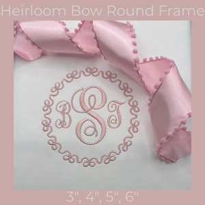 Op de afbeelding: Een witte stof met een roze geborduurd monogram in een ronde lijst. Het monogram bevat de letters B, S en T. Een roze lint met pomponafwerking is over de bovenkant gedrapeerd. De tekst "Heirloom Bow Round Frame" en de maten 3", 4", 5", 6" zijn ook zichtbaar.