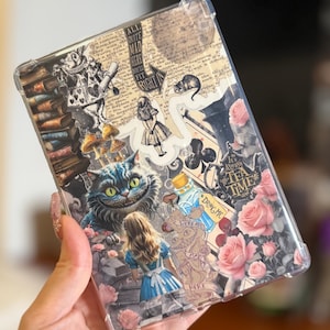 May include: Clear phone case featuring Alice in Wonderland imagery. The design includes illustrations of the Cheshire Cat, Alice, roses, and text elements. The case has a transparent border.
