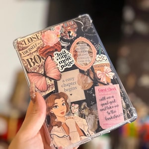 May include: Clear phone case with a collage design. Features a pink butterfly, floral accents, and text that reads "Just one more page" and "call me a good girl and take me to the bookstore". Includes a cartoon image of a woman.