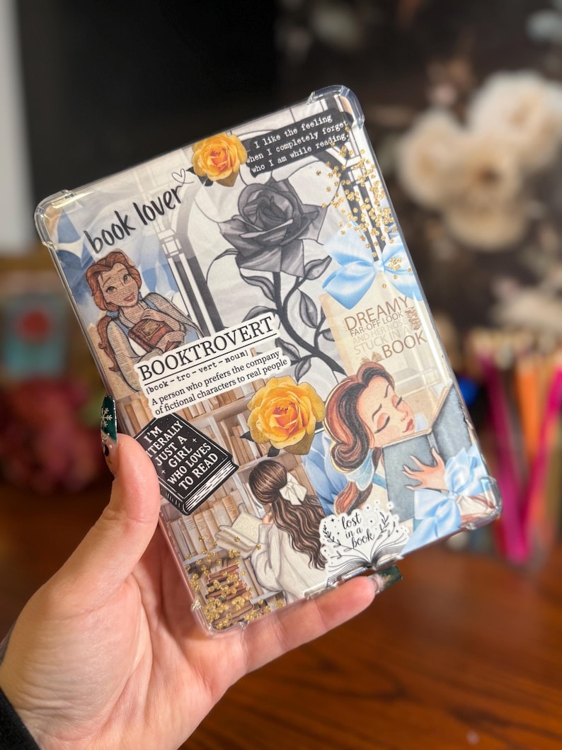 May include: Clear tablet case with a collage design featuring illustrations of Belle from Beauty and the Beast, roses, and book-related quotes. The case has the words "book lover" and "Booktrovert" printed on it.