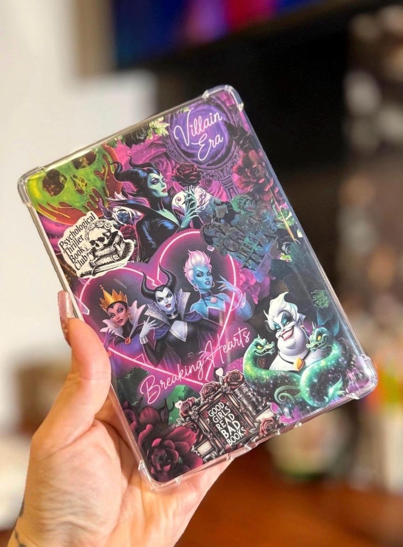May include: A clear phone case featuring a collage of Disney villains. The design includes images of Maleficent, Ursula, and the Evil Queen, with text that reads "Villain Era", "Breaking Hearts", and "Good Girls Read Bad Books".