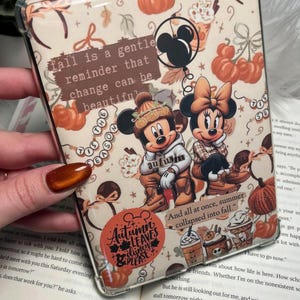 Op de afbeelding: Een doorzichtige tablethoes met een herfstpatroon met Mickey en Minnie Mouse, pompoenen en koffiebekers. De tekst bevat: fall is a gentle reminder that change can be beautiful, 'tis the season, autumn en And all at once, summer collapsed into fall.