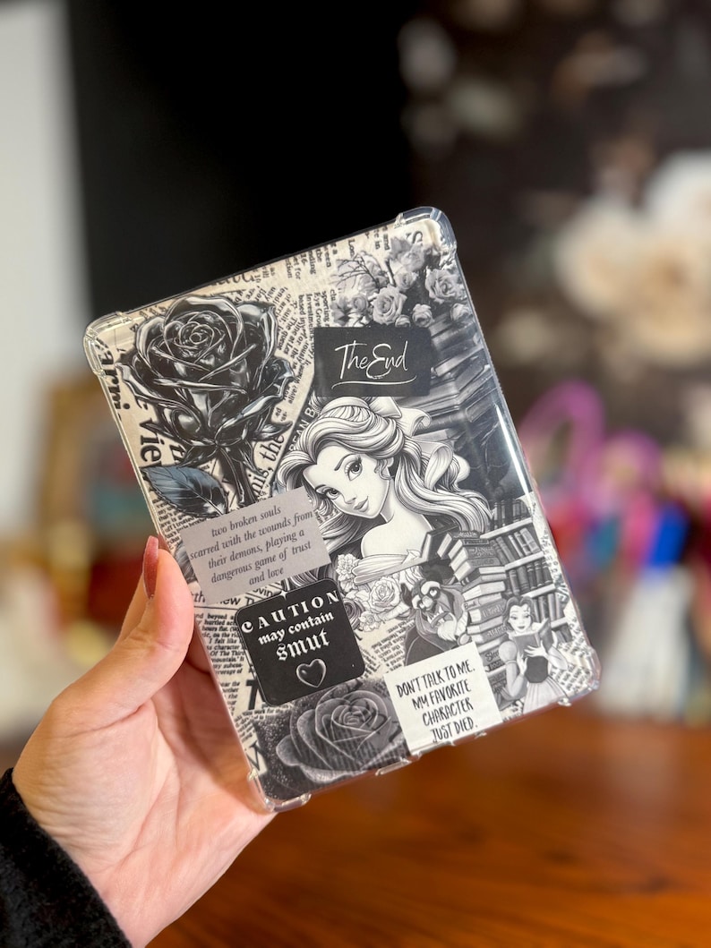 May include: Clear phone case with a black and white collage design. The design includes roses, a portrait of a woman, and text that reads "The End", "CAUTION may contain smut", and "DON'T TALK TO ME MY FAVORITE CHARACTER JUST DIED".