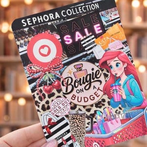 May include: A decorative card with the text "SEPHORA COLLECTION" and "SALE" in pink. The card features a cartoon of a mermaid drinking from a cup, a shopping cart, and various beauty product illustrations.