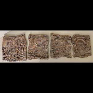 May include: Four brown, rectangular wall art panels with detailed relief carvings. Each panel features a unique, textured design with organic shapes and figures. The panels are mounted on a light-colored wall, creating a cohesive display.