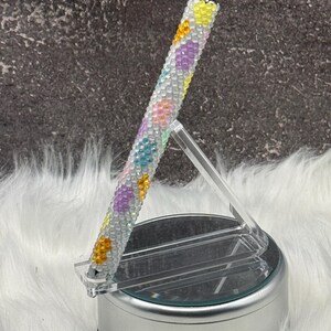 May include: A white ceramic mug with a black handle and the text "But First, Coffee" in a bold, black font. The mug is set against a neutral background, highlighting its simple design.