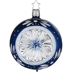 Könnte beinhalten: Runde, marineblaue Weihnachtskugel mit silbernem Glitzerband und weißen Blumenakzenten. Die Mitte zeigt ein klares, blütenartiges Design. Ein silberner Stern ziert die Oberseite der Kugel.