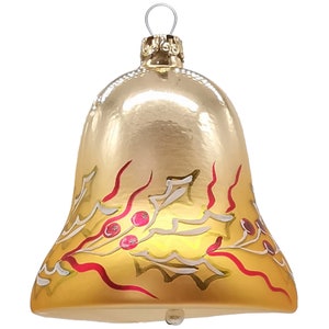 Könnte beinhalten: Goldene Weihnachtsglocke mit rotem und weißem Stechpalmen-Design.