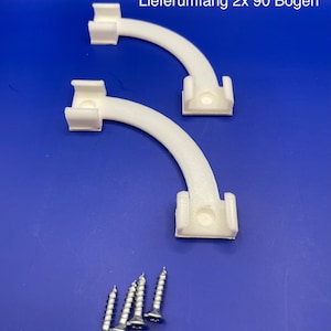 Puede incluir: Dos soportes de esquina de plástico blanco de 90 grados con cuatro tornillos plateados. El texto "Lieferumfang 2x 90 Bogen" es visible en la esquina superior derecha de la imagen.