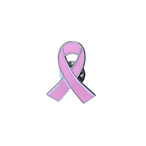 Peut inclure: Une épingle à ruban rose avec un bord argenté. L'épingle est un symbole de sensibilisation au cancer du sein. Le ruban est une boucle avec une épingle au dos pour l'attacher. L'épingle est sur fond blanc.