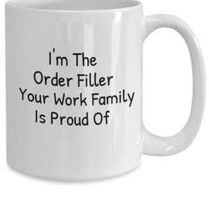 Peut inclure: Une tasse à café en céramique blanche avec du texte noir qui dit "I'm The Order Filler Your Work Family Is Proud Of"