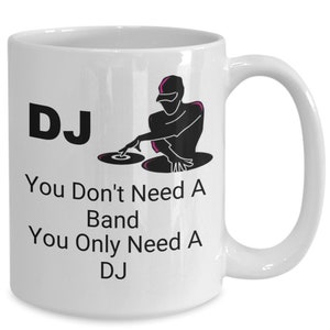 May include: White ceramic coffee mug with a black silhouette of a DJ spinning records. The text "DJ You Don't Need A Band You Only Need A DJ" is printed on the mug.