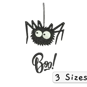 Könnte beinhalten: Schwarze und weiße Stickerei-Design einer Spinne mit Glitzern, die an einer Schnur hängt, mit dem Wort "Boo!" darunter. Das Design ist in drei Größen erhältlich.