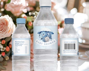 May include: Three clear plastic water bottles with blue and white labels. The center bottle has a blue and white floral design with the text "BABY SHOWER". The bottle on the left has a nutrition facts label. The bottle on the right has the text "JESSICA GARDNER" and "BABY SHOWER AUG 24, 2025".