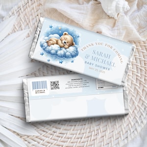 May include: Blue and white chocolate bar wrapper with a cartoon bear sleeping on a cloud. The wrapper says "Thank you for coming, Sarah & Michael, Baby Shower, May 25, 2025".
