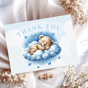 Może przedstawiać: Niebieska kartka z podziękowaniem z białą ramką. Na kartce znajduje się rysunek animowany przedstawiający brązowego pluszowego misia śpiącego na niebieskiej chmurze z złotymi gwiazdami. Tekst "THANK YOU" jest wydrukowany na kartce na biało.