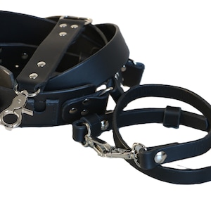 Puede incluir: Correa de cámara de cuero negro con un clip de metal y una correa de muñeca de cuero negro separada.
