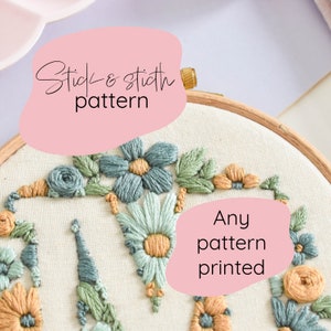 以下が含まれることがあります： 白い刺繍枠に、緑、青、黄色の糸で刺繍された花柄のアップ。ピンクの背景に黒い文字で「Stick & stitch pattern」と書いてある。ピンクの背景に黒い文字で「Any pattern printed」と書いてある。