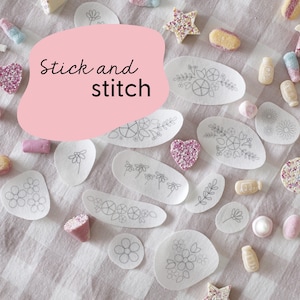 Może przedstawiać: Zbliżenie na białą powierzchnię z różnymi kształtami białego materiału z czarnymi rysunkami kwiatów i liści. Tekst "Stick and stitch" jest napisany czarnym kolorem na różowym tle.