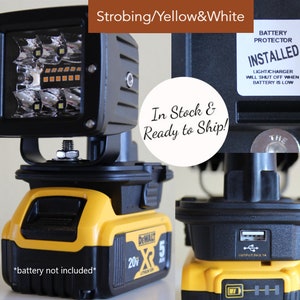 May include: A black and yellow work light with a strobe feature. The light is powered by a 20V DeWalt battery. The light has a USB port and a battery protector that shuts off the light when the battery is low. The text "BATTERY PROTECTOR INSTALLED" and "LIGHT CHARGER WILL SHUT OFF WHEN BATTERY IS LOW" is printed on a white sticker on the light. The text "In Stock & Ready to Ship!" is printed on a white circle.