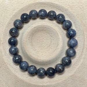 Pode incluir: Um bracelete de pedras preciosas azul escuro com contas redondas. O bracelete &eacute; feito de pedras naturais e tem aproximadamente 18 cm de comprimento.