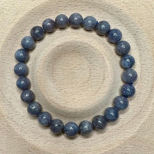 Pode incluir: Um bracelete de pedras preciosas cinzas com contas redondas. O bracelete &eacute; feito de pedras naturais e tem aproximadamente 20 cm de comprimento.