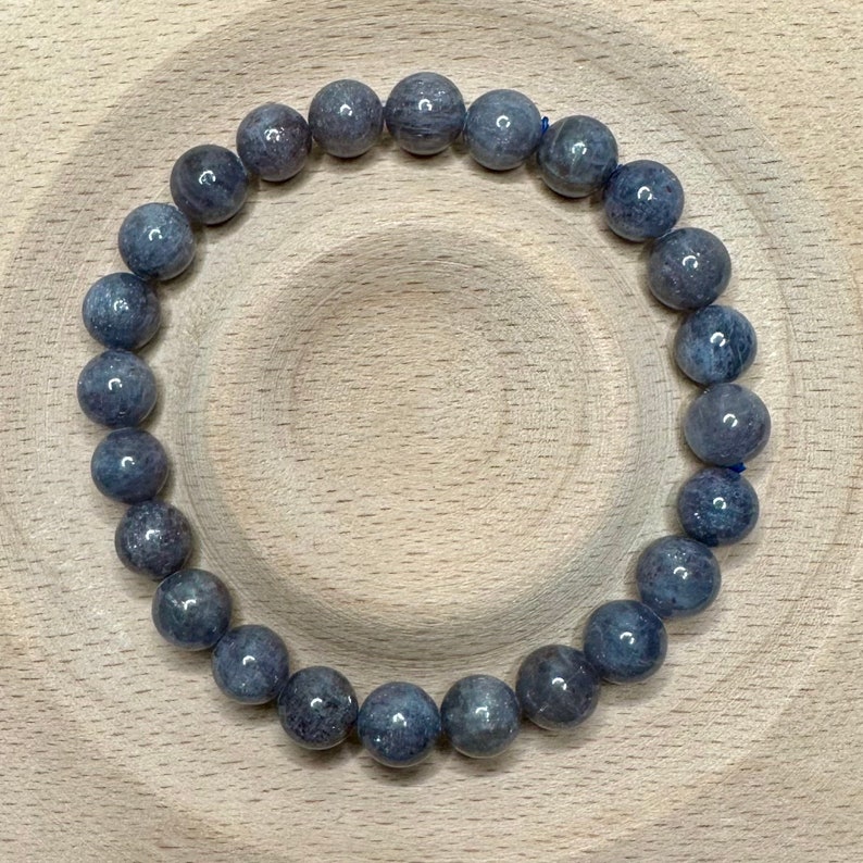 Pode incluir: Um bracelete de pedras preciosas cinzas com contas redondas. O bracelete &eacute; feito de pedras naturais e tem aproximadamente 20 cm de comprimento.