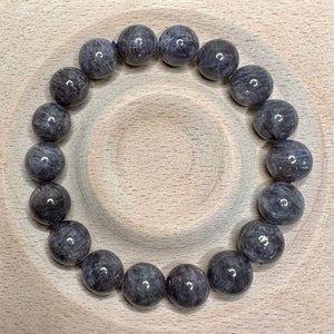 Pode incluir: Um bracelete feito de contas redondas de pedra preciosa cinza escuro.