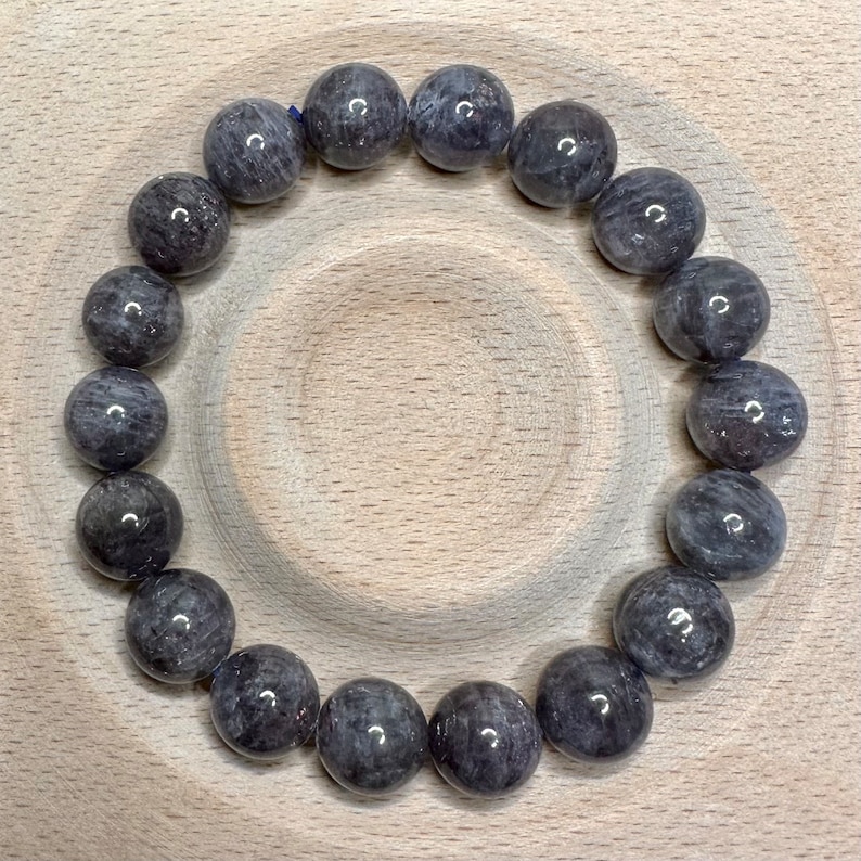 Pode incluir: Um bracelete feito de contas redondas de pedra preciosa cinza escuro.