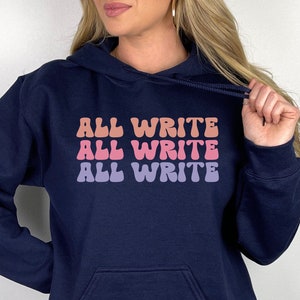 May include: Navy blue hoodie with a white graphic that says "ALL WRITE" three times in a retro font with pink, orange, and purple color variations.