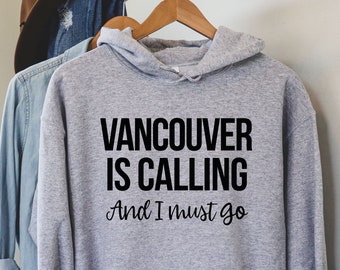 May include: A gray hooded sweatshirt with the text "Vancouver is calling and I must go" printed in black.