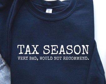 May include: A navy blue sweatshirt with the text "TAX SEASON VERY BAD, WOULD NOT RECOMMEND." printed in white.