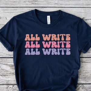 May include: A navy blue t-shirt with the words "ALL WRITE" in three rows, each in a different color: peach, pink, and purple. The text has a retro, wavy font. The shirt is knotted at the bottom.