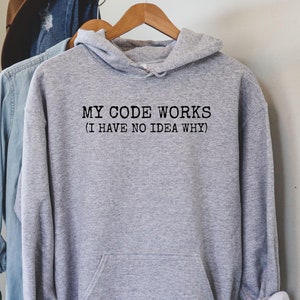 May include: A gray hooded sweatshirt with the text "MY CODE WORKS (I HAVE NO IDEA WHY)" printed on the front.