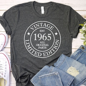 May include: A dark gray t-shirt with a white circle graphic that says "Vintage Est. 1965 All Original Parts Limited Edition".